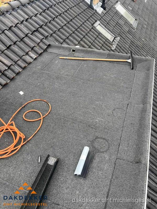 Plat dak reparatie met gereedschap en loodstroken in Sint Michielsgestel
