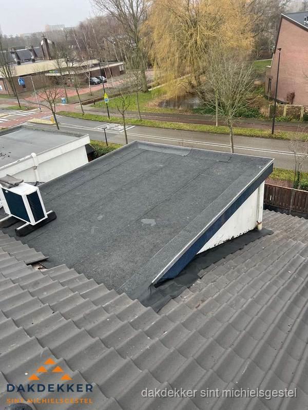 Plat dak met bitumen dakbedekking naast schuin pannendak in Sint Michielsgestel