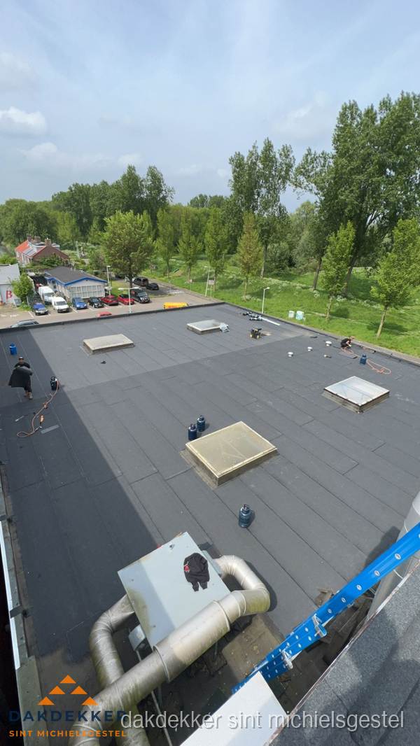 Dakdekker aan het werk op groot plat dak met bitumen in Sint Michielsgestel