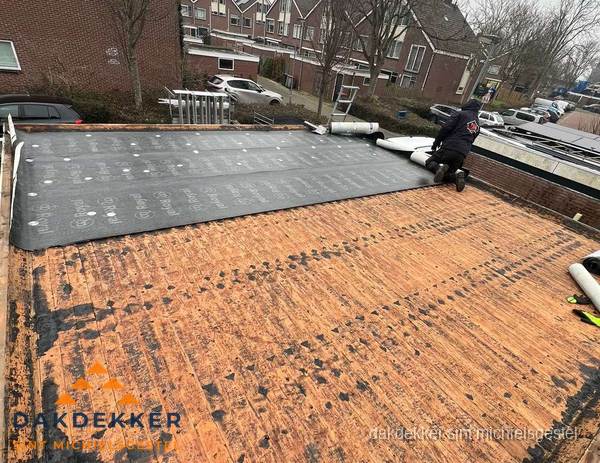 Dakdekker legt onderlaag op plat dak met houten constructie in Sint Michielsgestel
