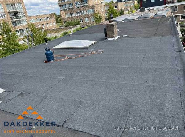 Bitumen dakbedekking op plat dak met lichtkoepel en schoorsteen in Sint Michielsgestel
