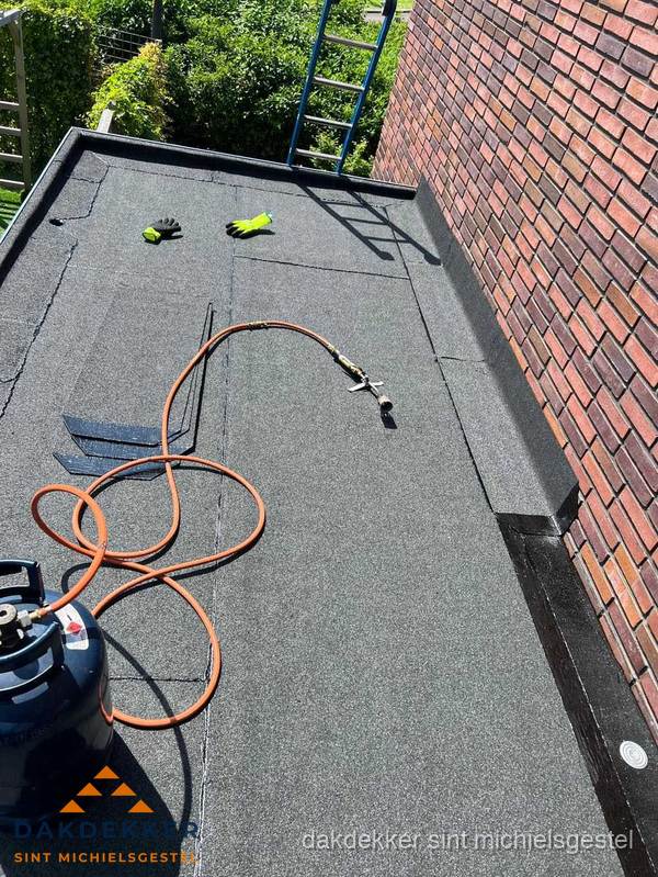 Plat dak met bitumen en brandgereedschap van dakdekkersbedrijf in Sint Michielsgestel