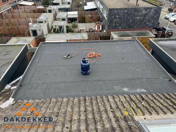 Plat dak met nieuwe bitumen dakbedekking en brandgereedschap in Sint Michielsgestel